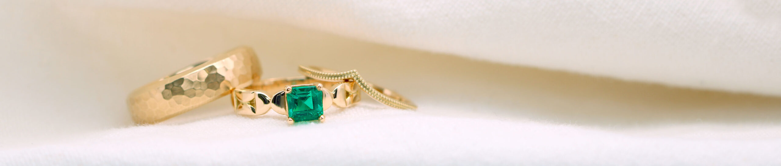 Custom jewelry one emerald ring an d two gold wedding bands