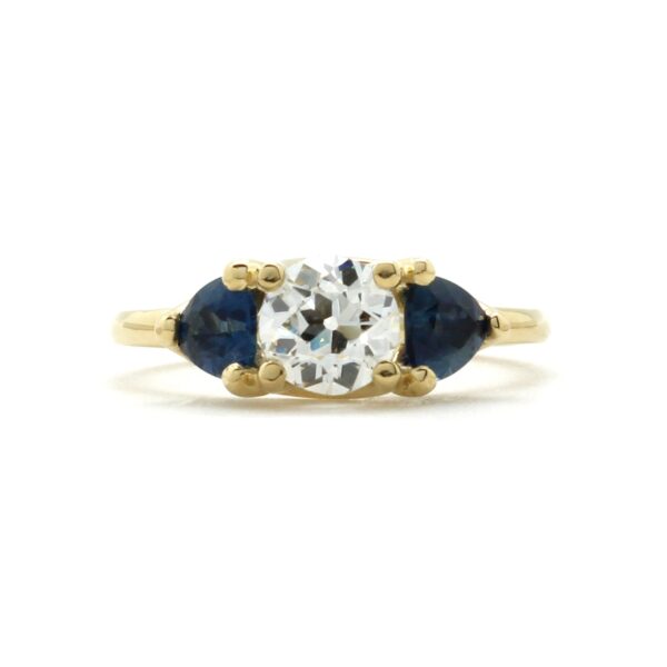 Old mine cut diamond three stone ring with blue sapphire trillion side stones in 18k yellow gold ring setting